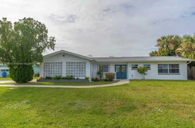 a view of a house with a yard and sitting area