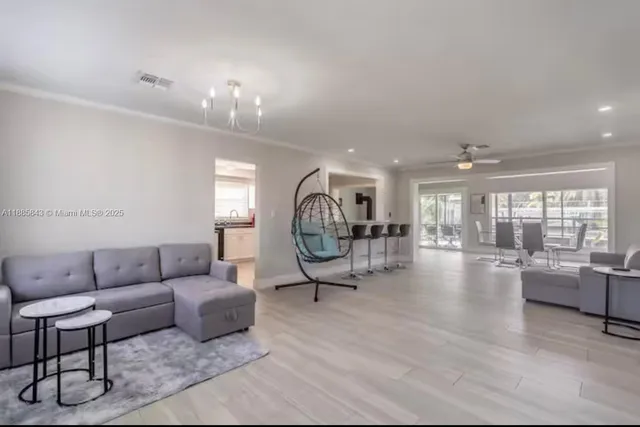 a living room with furniture a chandelier and a large window