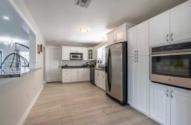 a kitchen with stainless steel appliances a refrigerator a stove top oven a sink and dishwasher