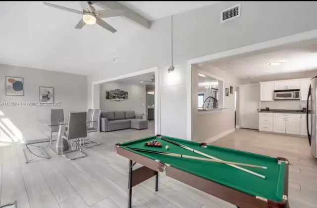 a room with pool table and windows