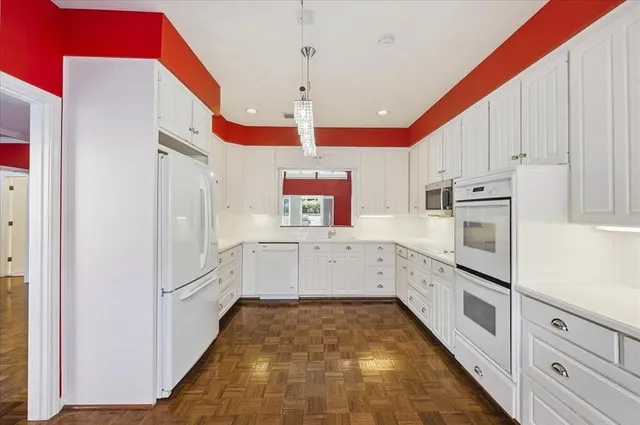 a kitchen with white cabinets and white appliances