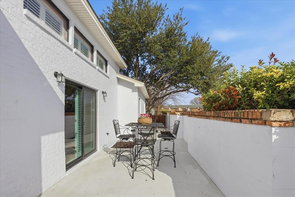 22 1 Main Place Benbrook, TX 76126 - Photo 37 of 40 a patio with table and chairs and potted plants with wooden floor and fence