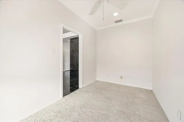 an empty room with a bathroom and chandelier