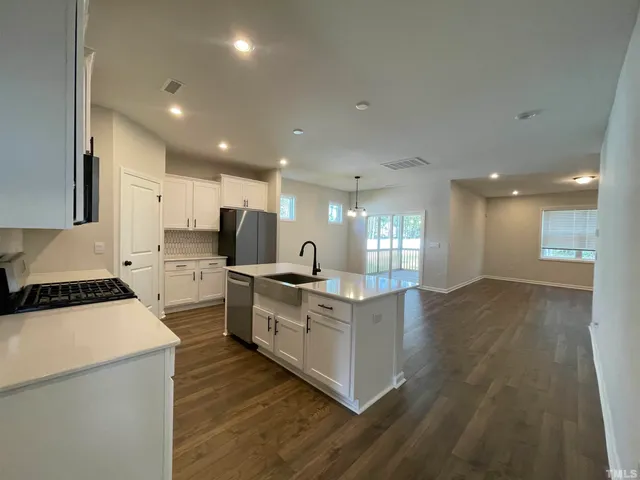 a kitchen with stove a sink and a refrigerator