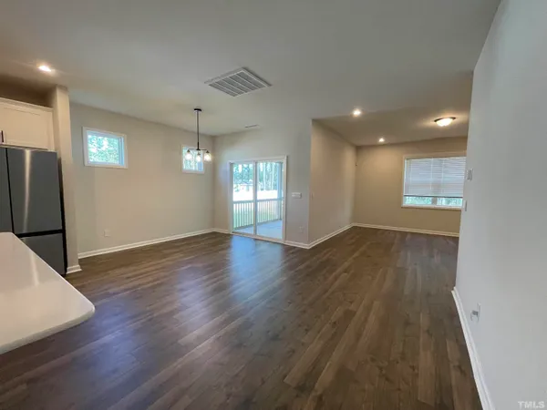 a view of empty room with wooden floor and window