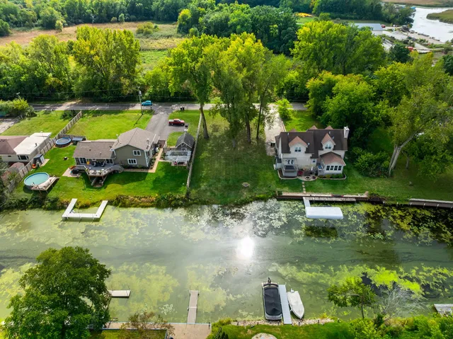 an aerial view of lake residential house with outdoor space and trees around