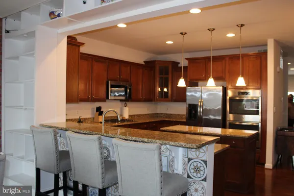 a kitchen with stainless steel appliances granite countertop a sink and a refrigerator