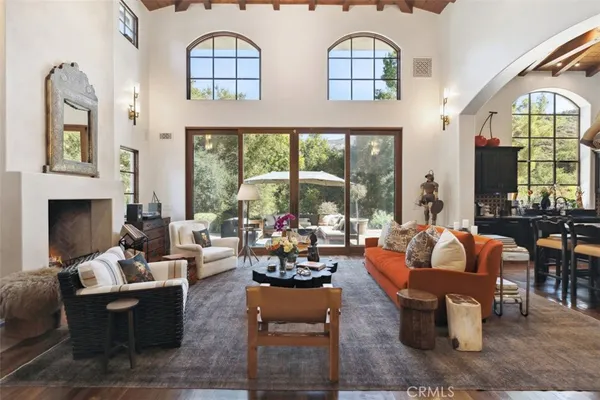 a living room with fireplace furniture and a large window