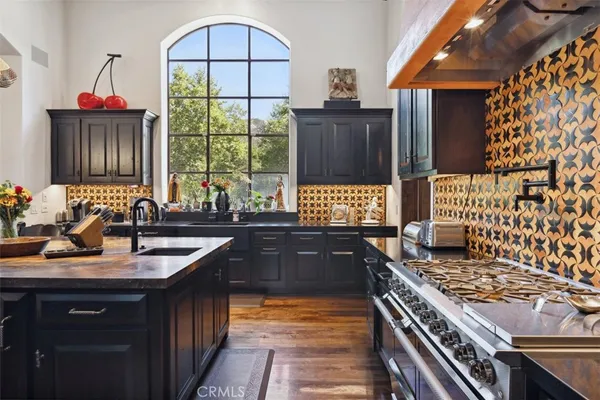 a kitchen with a sink stove top oven and cabinets