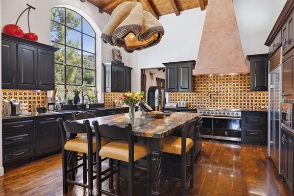 a kitchen with a sink a stove and chairs