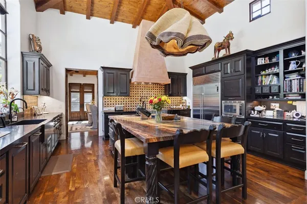 a dining hall with stainless steel appliances granite countertop a stove and chairs