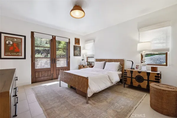 a spacious bedroom with a bed a dresser and a large window