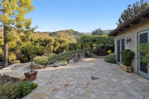 a view of a backyard with table and chairs and a large tree