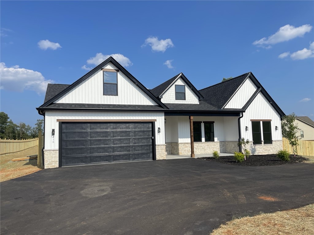 Modern farmhouse charm defines this newly constructed home with a spacious driveway and attached garage.