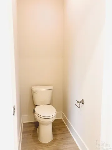 a white toilet sitting next to a white wall