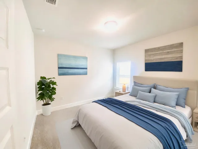 a bedroom with a bed and a painting on the wall