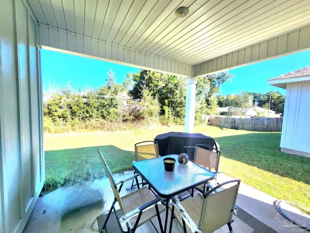 a view of an outdoor dining space with a table and chairs