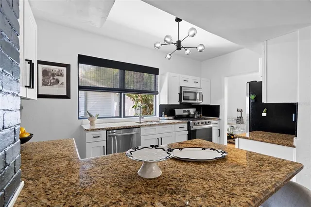 a kitchen with a stove a sink and a dining table