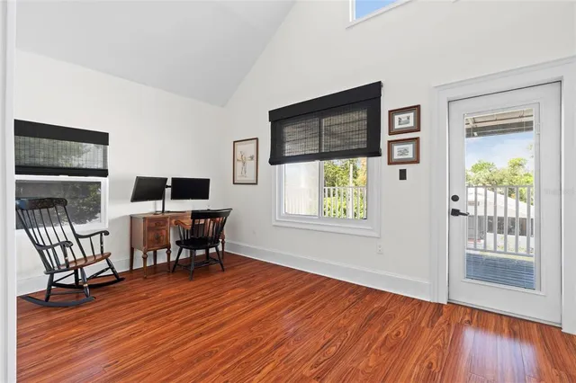 a workspace room with furniture wooden floor and windows
