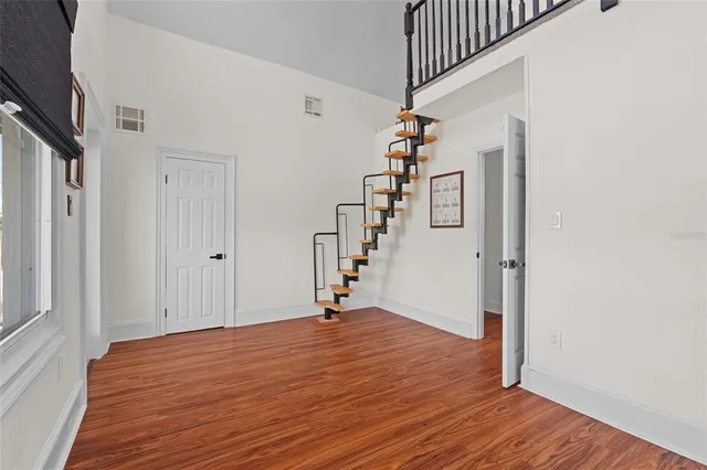 a view of a hallway with wooden floor and staircase