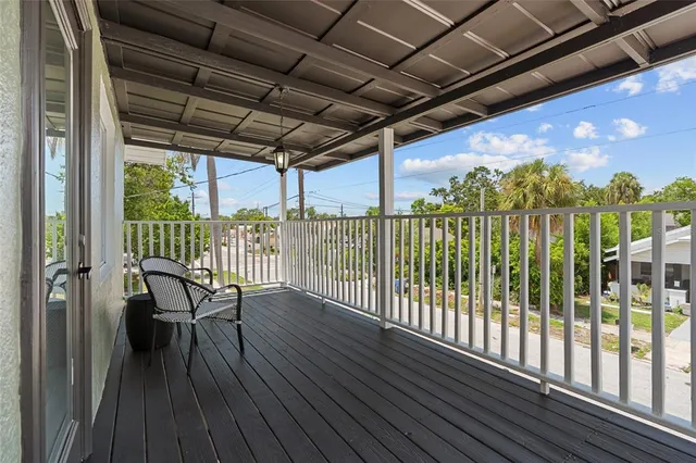 a view of a balcony with furniture and wooden floor