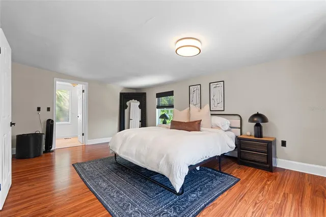 a spacious bedroom with a bed and wooden floor
