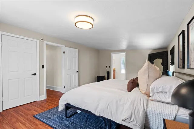 a spacious bedroom with a bed and wooden floor