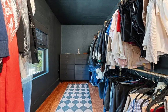 a view of walk in closet with clothes and shoes