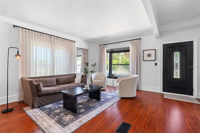 a living room with furniture and wooden floor