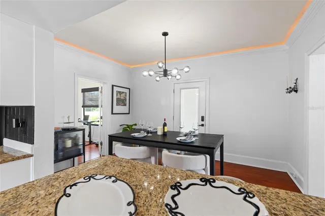 a living room with table chairs and a wooden floor