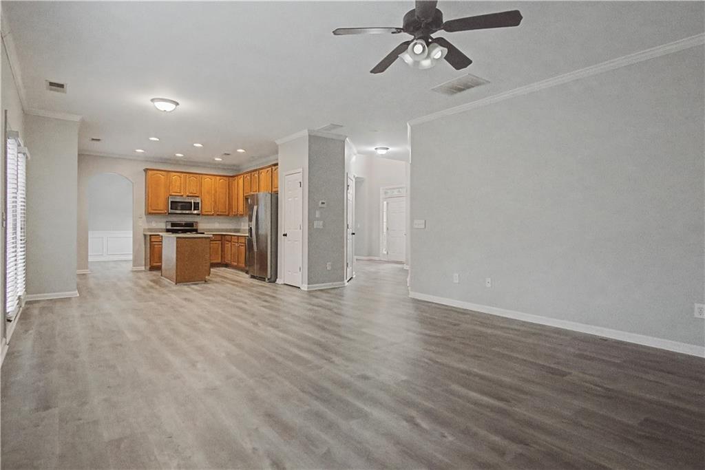 408 Long Branch Way Canton, GA 30115 - Photo 11 of 43 an empty room with wooden floor a ceiling fan and kitchen view