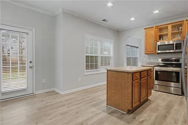 a kitchen with stainless steel appliances granite countertop a stove a microwave and a refrigerator