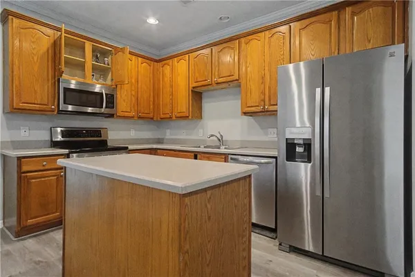 a kitchen with stainless steel appliances granite countertop a refrigerator a stove top oven a sink and dishwasher
