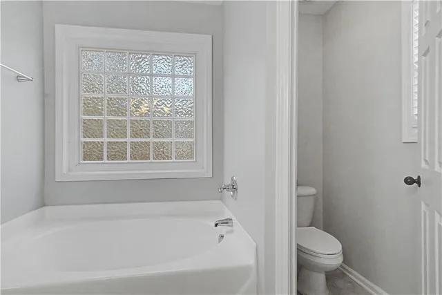 a white bath tub sitting next to a toilet