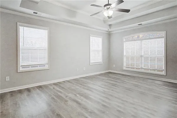 a view of an empty room with a window and a chandelier fan