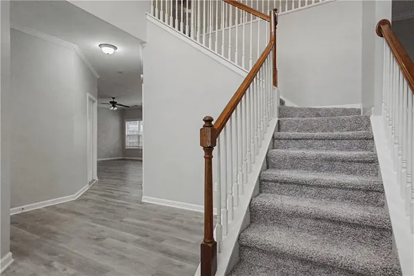 a view of staircase with wooden floor and white walls