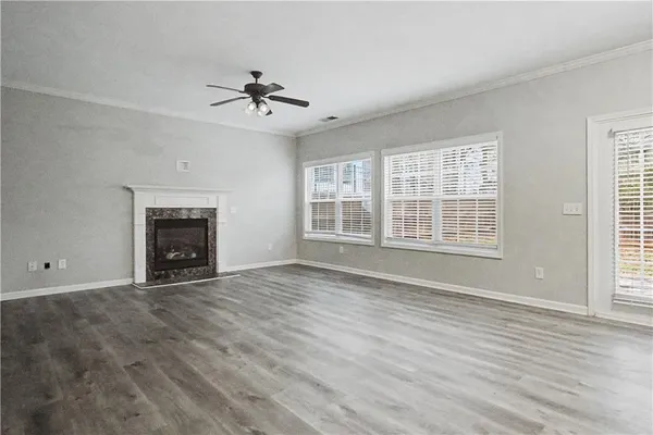 wooden floor fireplace and windows in an empty room
