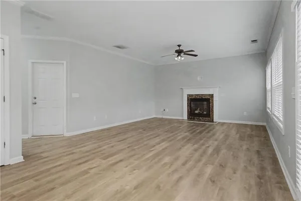 an empty room with fan and a fireplace