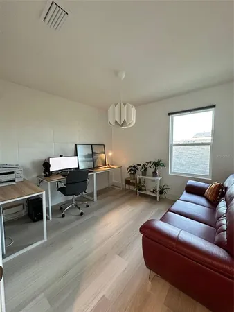 a bedroom with furniture and a large window