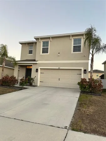 a view of a house with a yard and potted plants