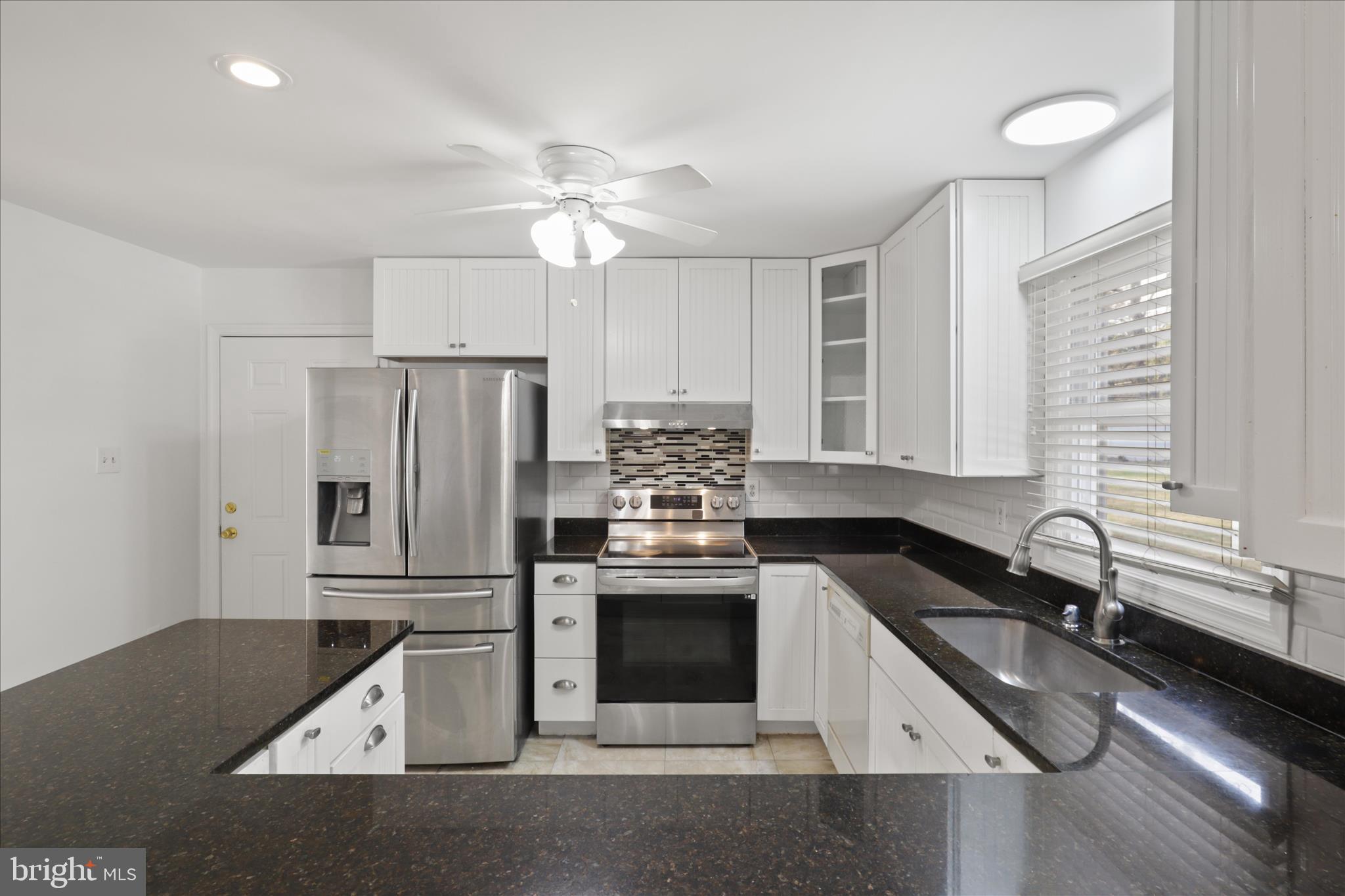 836 Utterback Store Road Great Falls, VA 22066 - Photo 3 of 30 a kitchen with granite countertop a stove sink and refrigerator