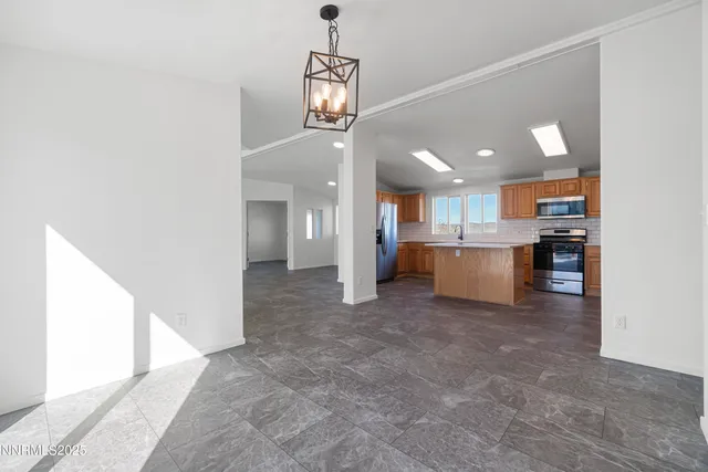 a kitchen with granite countertop a refrigerator oven a sink dishwasher and white cabinets with wooden floor