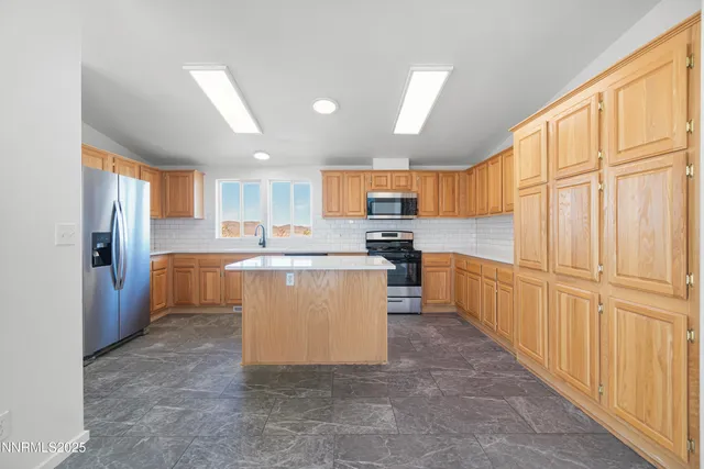 a large kitchen with stainless steel appliances granite countertop a refrigerator stove and a sink