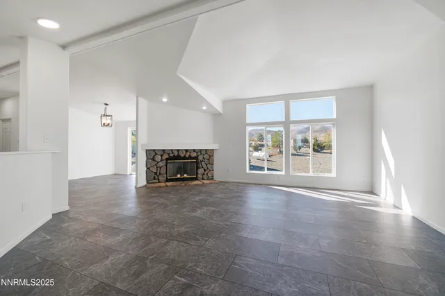 a view of an empty room with a fireplace and a window