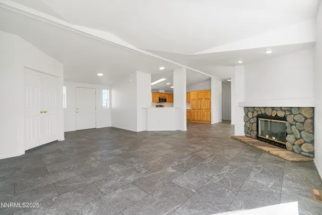 a view of an empty room with a fireplace and a window