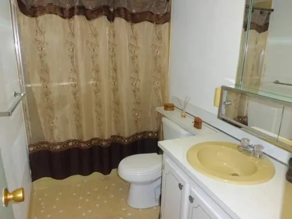 a bathroom with a sink a toilet and a mirror