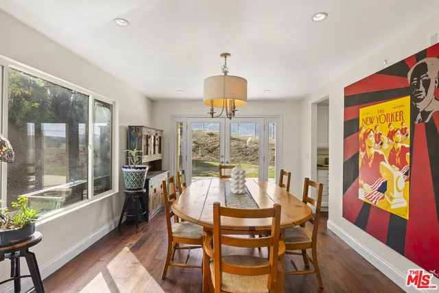 a dining room with furniture a chandelier and wooden floor
