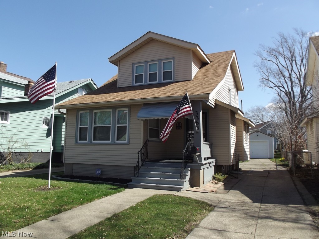 View of front of property featuring a front lawn and a garage
