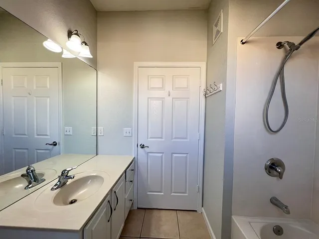 a bathroom with a granite countertop sink a mirror and shower