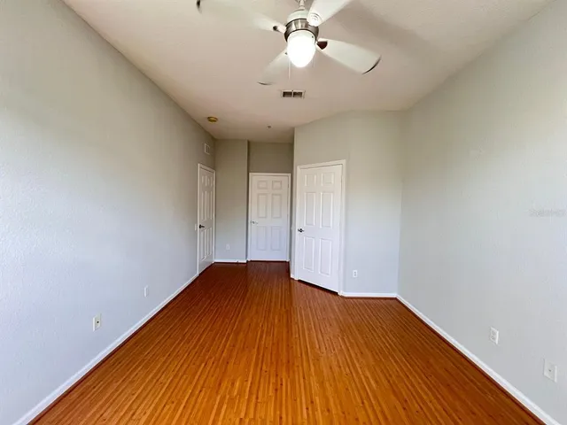 a view of empty room with wooden floor